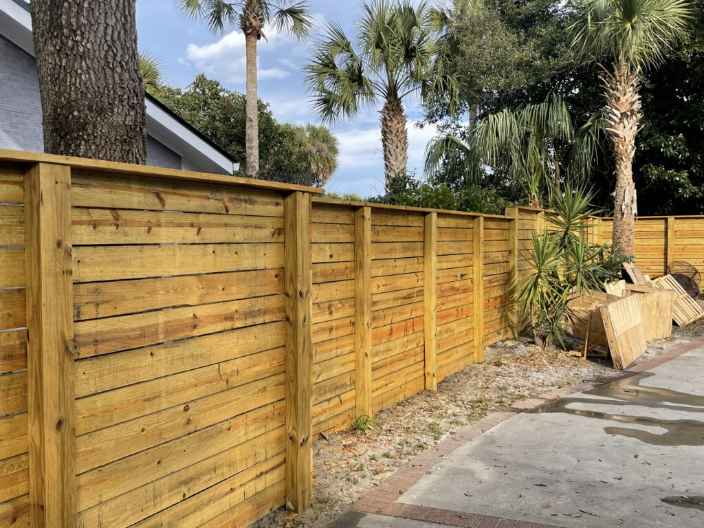 Horizontal cedar privacy fence along a concrete drive