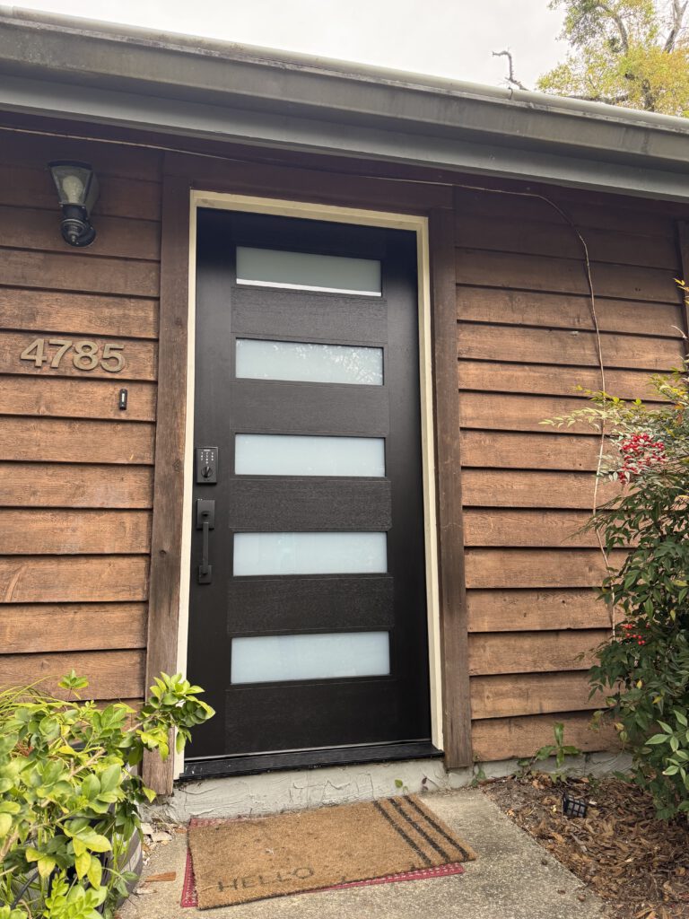 New modern entry door set into cedar shake siding