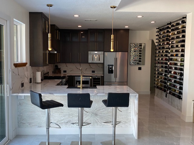 Kitchen with waterfall quartz island and dark cabinetry